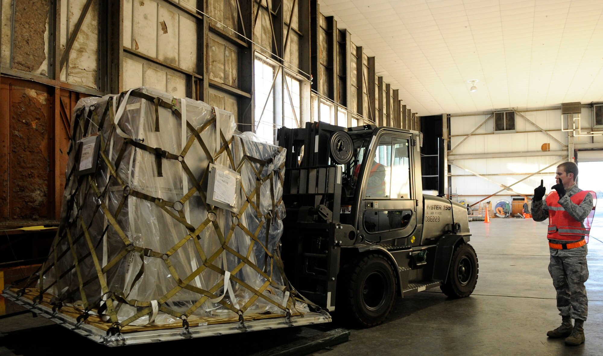 LANGLEY AIR FORCE BASE, Va. -- Airman 1st Class Ryan Sandmeier, Traffic Management Office journeymen with the 633d Logistics Readiness Squadron, marshals a forklift with equipment during a Phase I Operational Readiness Exercise Nov. 19. Wing Exercise Evaluation Team members spent two days assessing the ability of the 633d Air Base Wing, 1st Fighter Wing and 192d Fighter Wing to deploy cargo, aircraft and Airmen within a limited timeframe. (U.S. Air Force photo/Staff Sgt. Dana Hill)(RELEASED)