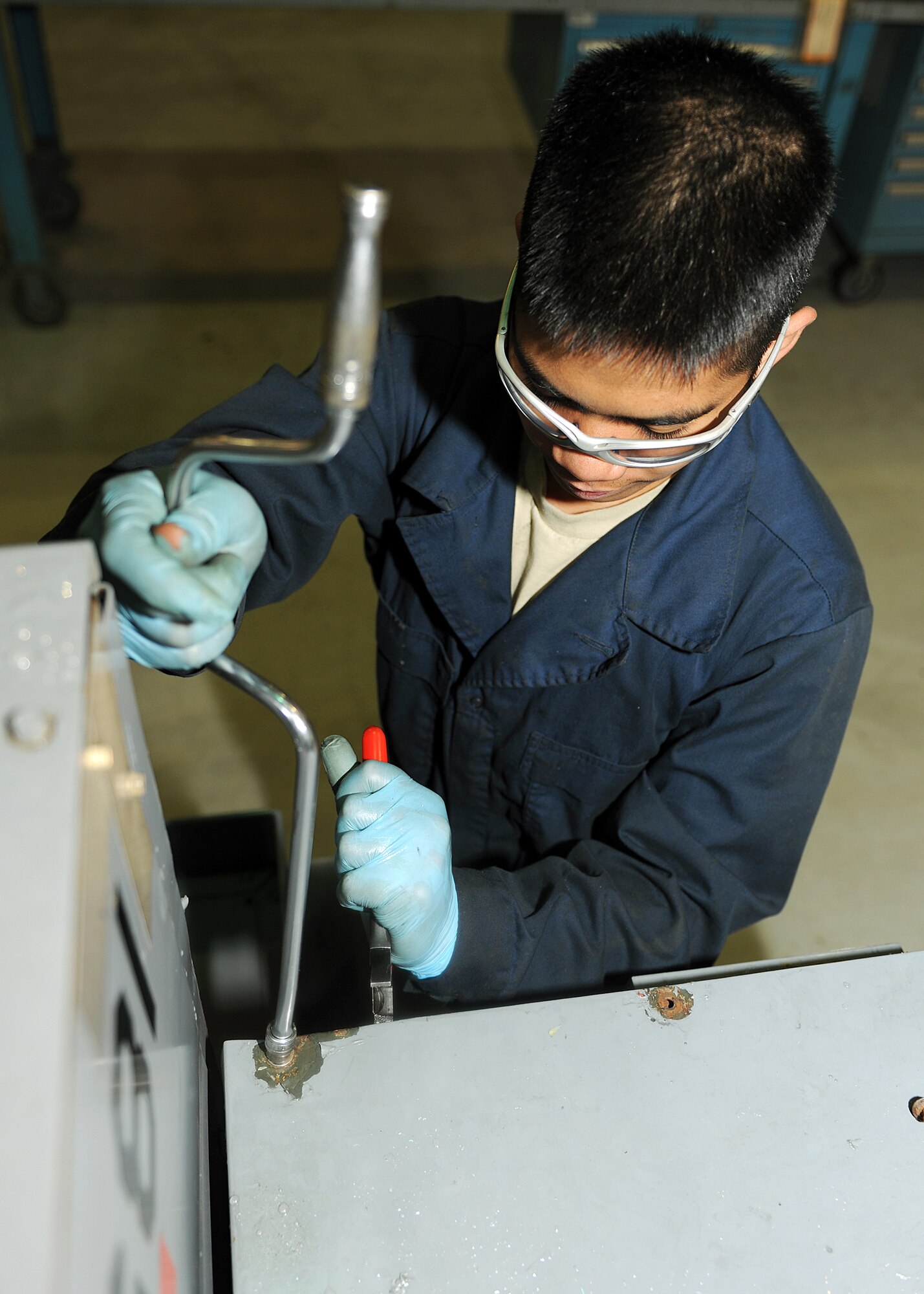 RAF MILDENHALL, England -- Airman Rikko Estrella, 100th Maintenance Squadron Aerospace Ground Equipment mechanic, removes a panel from a diesel engine generator as part of a Phase II inspection here Nov. 22, 2010.  The AGE shop performs bi-annual Phase II inspections as a preventative maintenance measure.  (U.S. Air Force photo/Senior Airman Tabitha M. Lee)