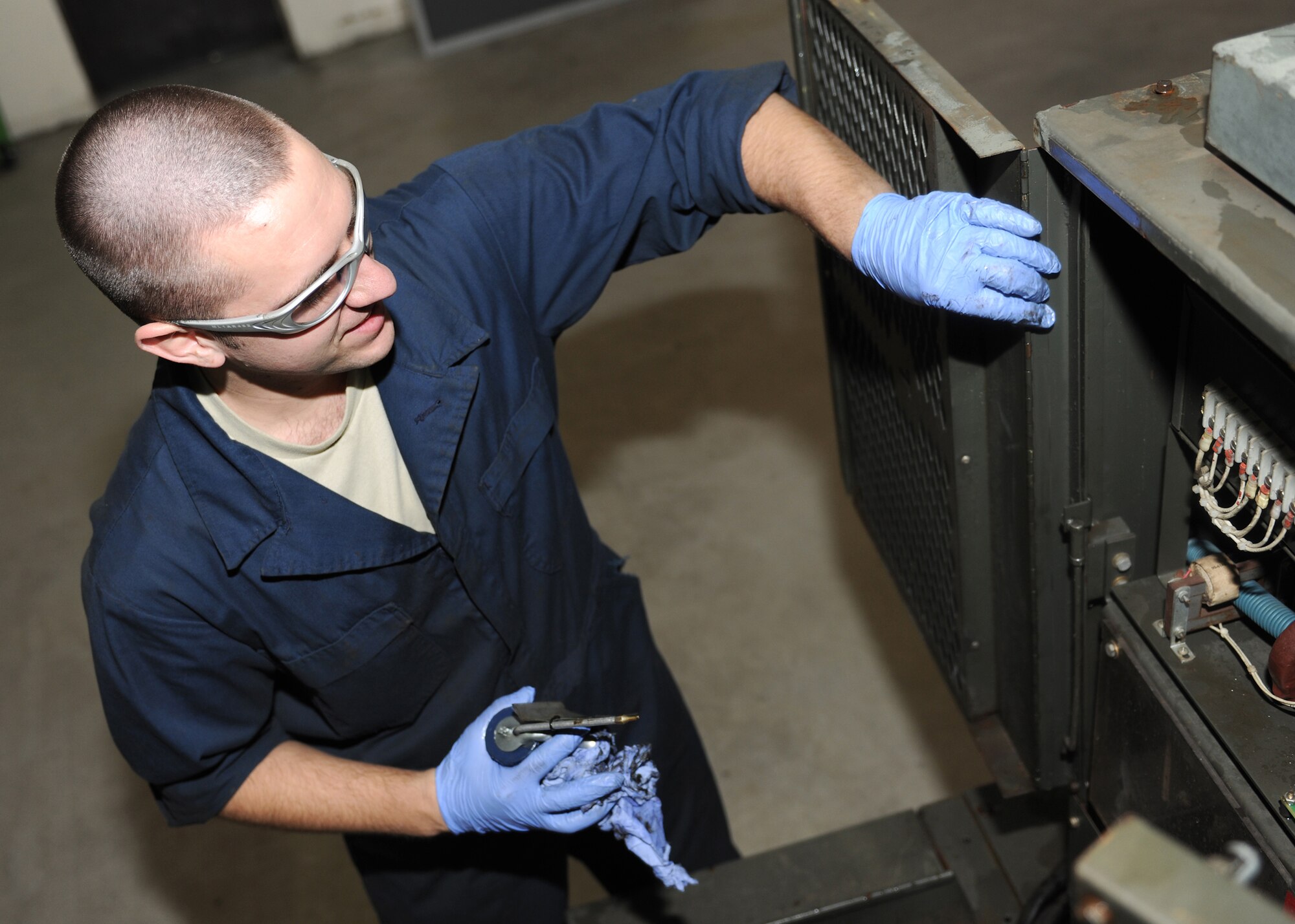 RAF MILDENHALL, England -- Airman 1st Class Chris Corley, 100th Maintenance Squadron Aerospace Ground Equipment mechanic, lubricates the door hinge on a diesel engine generator as part of a Phase II inspection here Nov. 22, 2010.  These inspections are done every six months to insure the integrity of the equipment.  (U.S. Air Force photo/Senior Airman Tabitha M. Lee)  