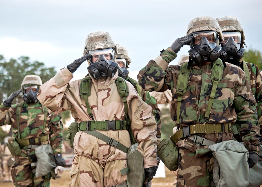 Senior Airman Heather Holland, with the 96th Force Support Squadron, and Staff Sgt. Michael Fleming, with the 96th Communications Squadron, salute during retreat Nov. 18, 2010, at Eglin Air Force Base, Fla. Approximately 50 Airmen attended the retreat ceremony in full mission oriented protective posture gear while attending training. (U.S. Air Force photo/Samuel King Jr.)