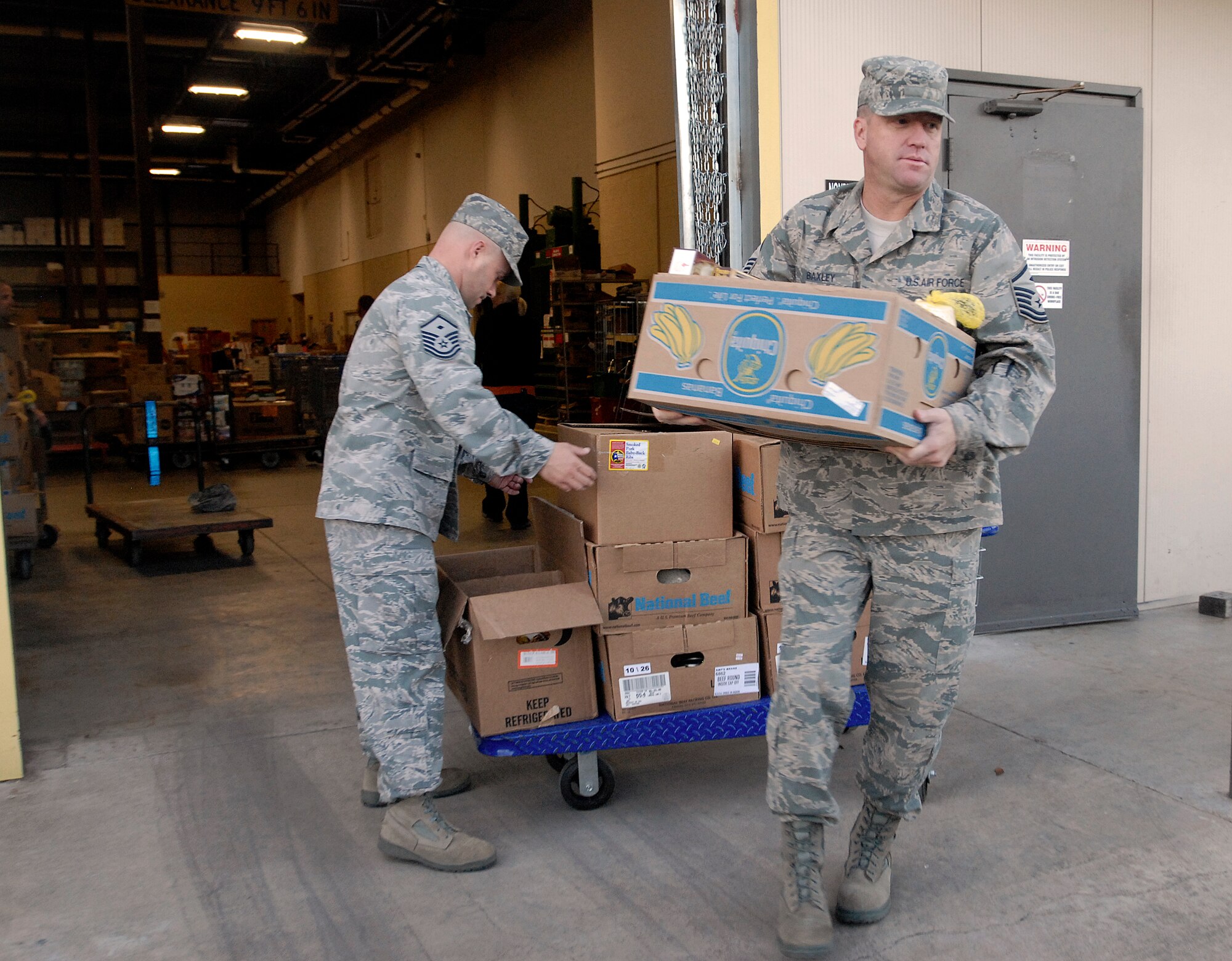 GOODFELLOW AFB, Texas – First Sergeants Master Sgt. Michael Miller, 17th Security Forces Squadron, and Master Sgt. James Baxley, 316th Training Squadron, grab boxes of donated food to load into a truck as part of “Operation Warmheart” Nov. 23.  Each year the Goodfellow First Sgt. Council conducts “Operation Warmheart” which aims to provide some holiday cheer by collecting food and toys for military families who may be in need during the holiday season. (U.S. Air Force photo/Master Sgt. Randy Mallard)