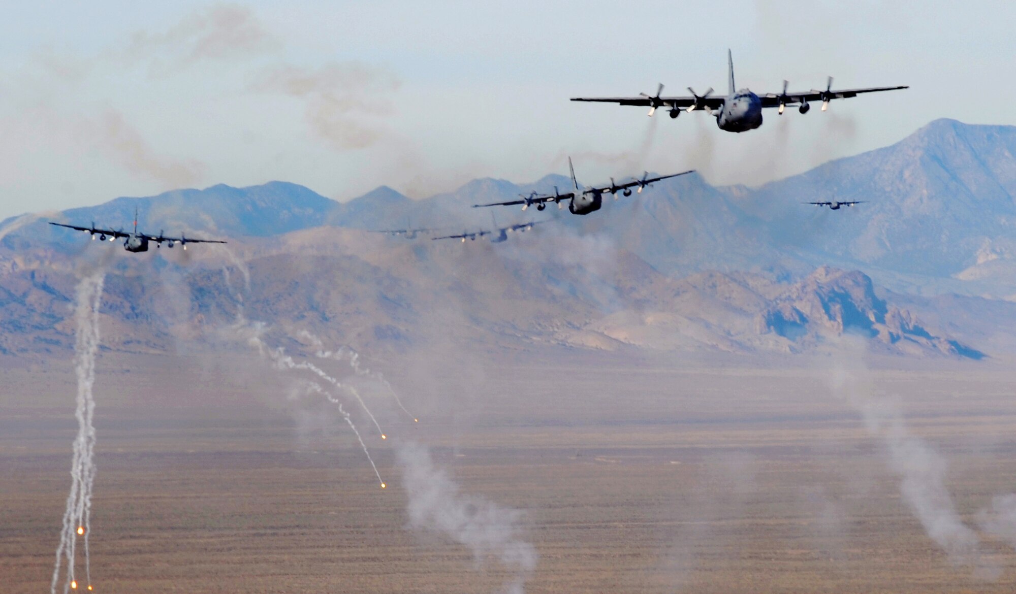 A formation of C-130 Hercules aircraft fire off chaff and flare countermeasures over the Nevada Test and Training Range Nov. 17, 2010 during a mobility air forces exercise. More than 40 C-17 Globemaster IIIs and C-130s assembled in aerial formations over the range to conduct air and ground operations. (U.S. Air Force photo/Master Sgt. Kevin J. Gruenwald) 