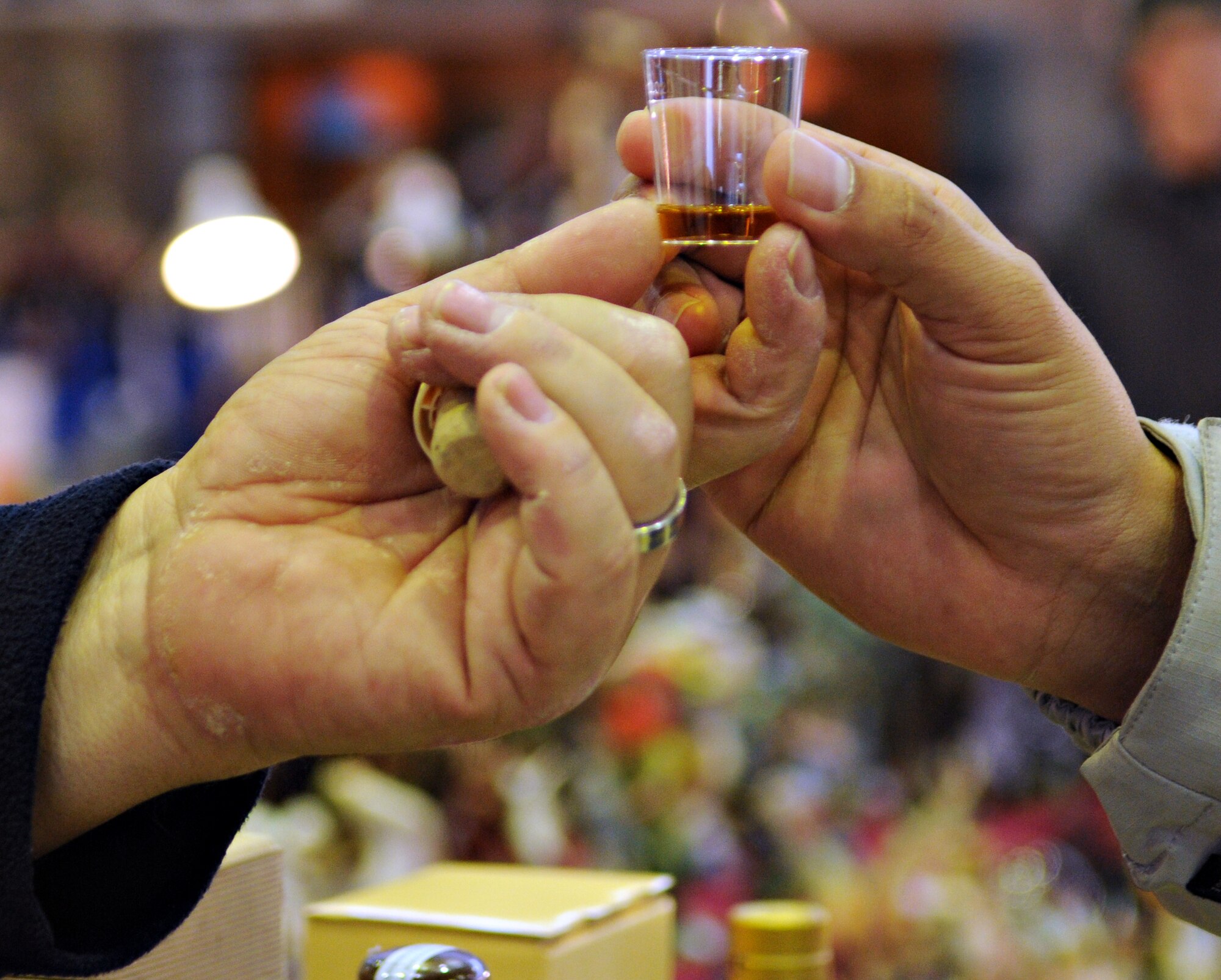 SPANGDAHLEM AIR BASE, Germany – A vendor at the Eifel Holiday Bazaar hands a sample of holiday spirit to a customer Nov. 19. The bazaar was hosted by the Spangdahlem’s Officer’s and Civilian’s Spouses’ Club and included vendors from across Europe. (U.S. Air Force photo/Staff Sgt. Benjamin Wilson)