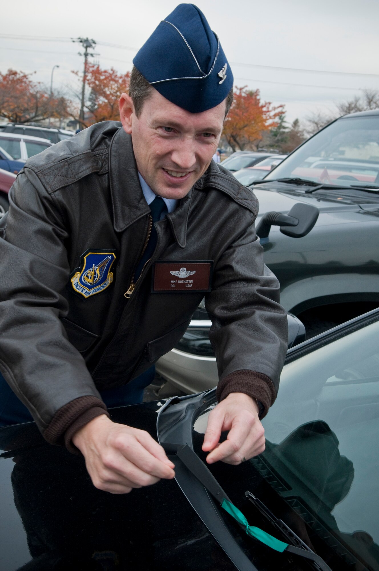U.S. Air Force Col. Michael Rothstein, 35th Fighter Wing commander, ties a green ribbon onto the windshield of a vehicle, Nov. 22, 2010, at Misawa Air Base, Japan during the 16th Annual Green Ribbon ‘Tie One On’ campaign. The ribbons serve as a visible reminder to Airmen to drink responsibly and have a plan. (U.S. Air Force photo by Senior Airman Jessica Lockoski/Released) 