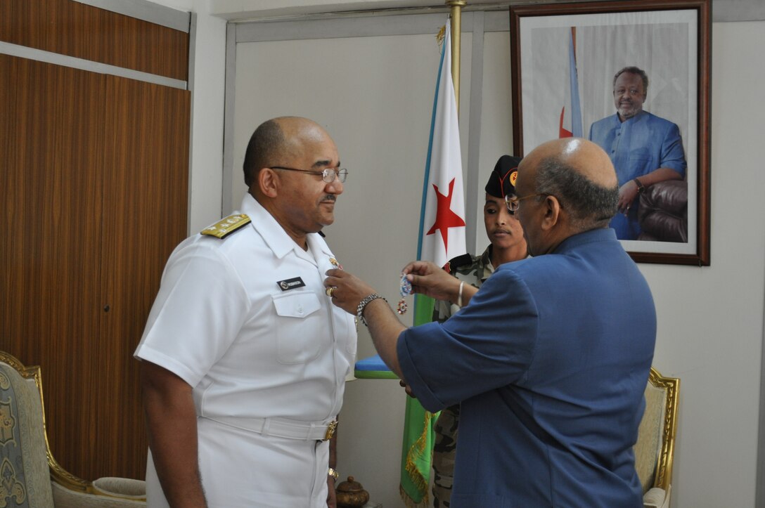 U.S. Navy Surgeon General Vice Adm. Adam M. Robinson Jr. receives the Djibouti Medal of the Commander of the National Order, that nation's highest award, by Djibouti Prime Minister Dileita Mohamed Dileita. Robinson accepted the award on behalf of the U.S. Navy Medical Research Unit-3, whose work over the past decade has enhanced infectious disease surveillance in Djibouti. U.S. Navy photo by Capt. Cappy Surette