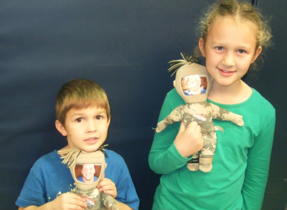 Ariana and Angelo Scarpulla pose with their “daddy dolls” to keep their father, Army Sgt. 1st Class Wayne Scarpulla, close at hand over the holidays. Scarpulla is on his fifth deployment in a dozen years. Courtesy photo