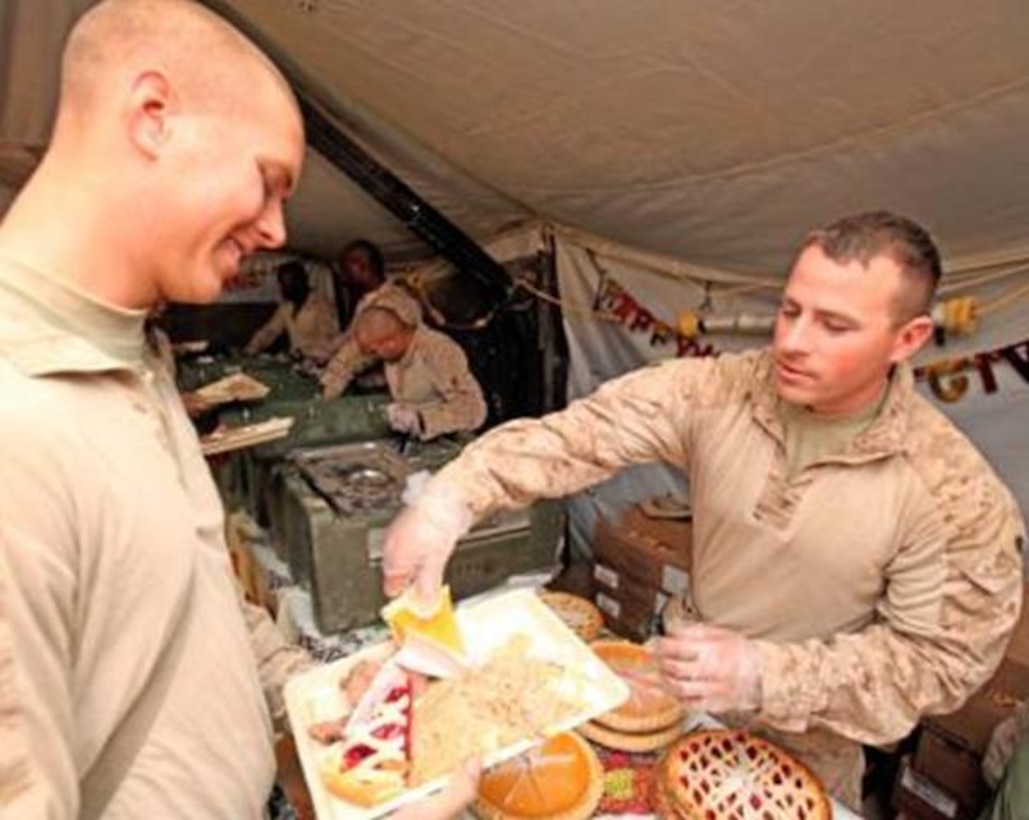 Cpl. Michael H. Whorton, an intelligence analyst, with 2nd Battalion, 9th Marines, smiles while eating his Thanksgiving Day dinner at Marine Corps Forward Operating Base Camp Hansen, Nov 25. Marine food specialists managed to prepare approximately 550 pounds of turkey, 400 pounds of ham, 330 pounds of steak and serve over 2000 slices of pie in 2/9’s area of operation.