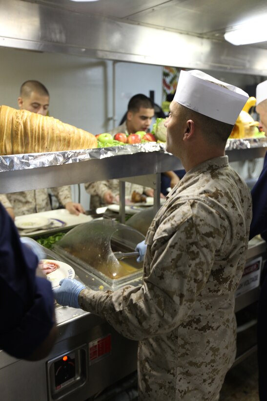 Gunnery Sgt. Jeremiah Warnick, fires chief for 26th Marine Expeditionary Unit, serves Thanksgiving dinner to Marines and sailors aboard USS Kearsarge, Nov. 25, 2010. 26th MEU is deployed aboard the ships of the Kearsarge Amphibious Ready Group in the 5th Fleet area of responsibility and acting as the theater reserve force.