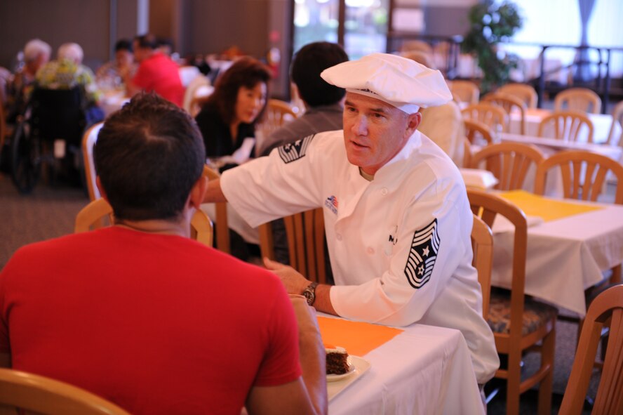 Chief Master Sgt. Brooke McLean, Pacific Air Forces command chief, talks to an Airman after serving turkey on Thanksgiving Nov. 25, 2010 at the Hale Aina Dining Facility at Joint Base Pearl Harbor-Hickam, Hawaii. Senior leadership from PACAF joined leaders from 13th Air Force and the 15th Wing to serve dinner to Airmen, dependents, family members and retirees. Several members of the Air Force Civilian Advisory Council also volunteered for the event. (U.S. Air Force photo/Tech. Sgt. Matthew McGovern)