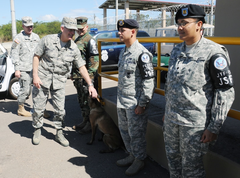 SOTO CANO AIR BASE, Honduras -- Saying hello to a military working dog, Gen. Douglas Fraser, the commander of the U.S. Southern Command, visits with members of the Joint Security Forces here Nov. 25. General Fraser visited with Team Bravo to thank them for their service. (U.S. Air Force photo/Tech. Sgt. Benjamin Rojek)