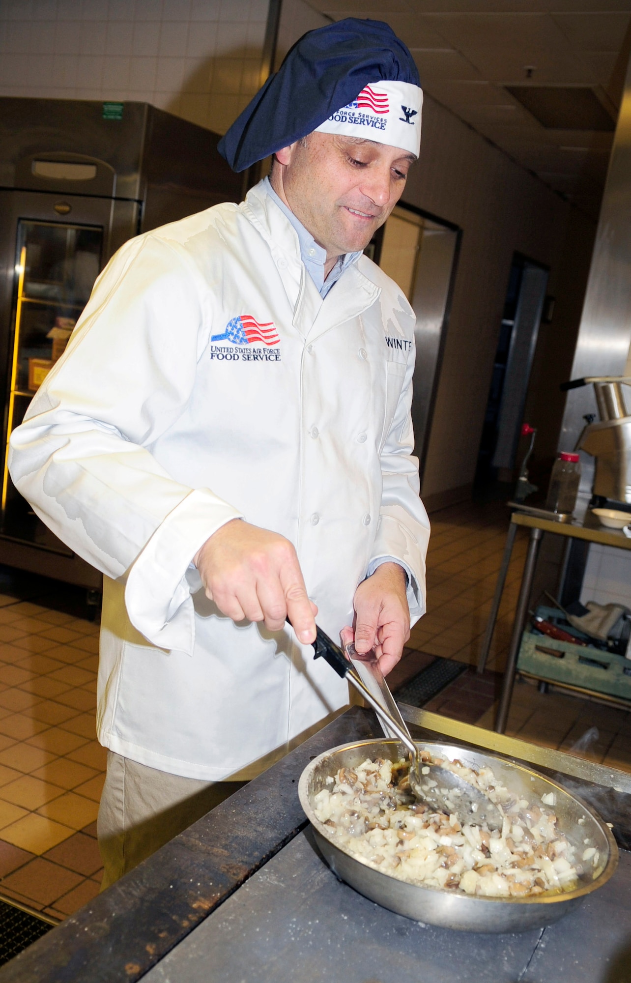 RAF MILDENHALL, England -- Col. Michael Winters, 100th Air Refueling Wing vice commander, takes over the stirring and cooking of a dish to be served in the Gateway Dining Facility Thanksgiving dinner Nov. 25, 2010. This was just one of the many tasks that Colonel Winters took upon himself to help out the Gateway Dining Facility staff, whether it was just a quick word to see how they were doing or helping them with the task at hand. (U.S. Air Force photo/Senior Airman Ethan Morgan)