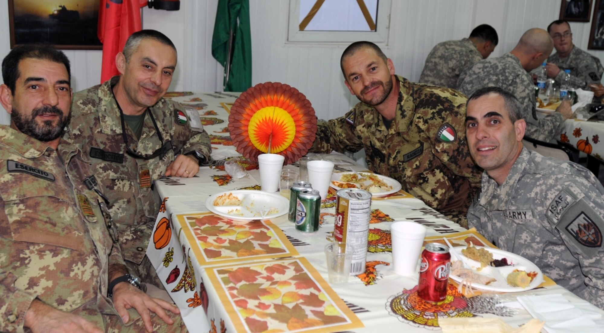 Italian, Spanish and U.S. servicemembers at Camp Arena, Herat province, Afghanistan, converse prior to a Thanksgiving dinner Nov. 25. (Left to right) Italian Army Warrant Officer Antonio Mellace, Army Warrant Officer Michelle Suppa, Army Lt. Col. Paolo Radizza, and U.S. Army Lt. Col. Phillip Cuccia all enjoy the international companionship during the American celebration. (U.S. Air Force photo/Tech. Sgt. Kevin Wallace)