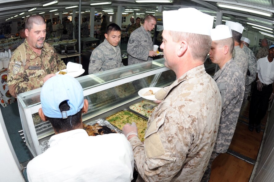 Italian, Spanish and U.S. servicemembers at Camp Arena, Herat province, Afghanistan, converse prior to a Thanksgiving dinner Nov. 25. U.S. Air Force Senior Airman Roberto Armas (center) and Staff Sgt. Chris Lenane, both deployed from McChord Air Force Base, Washington, were two such servicemembers.  For the American servicemembers living among 1,600 Italian soldiers and airmen, and a few hundred Spanish soldiers, Thanksgiving dinner was more-or-less a mission in the making, but proved to be successful in the end. (U.S. Air Force photo/Tech. Sgt. Kevin Wallace)
