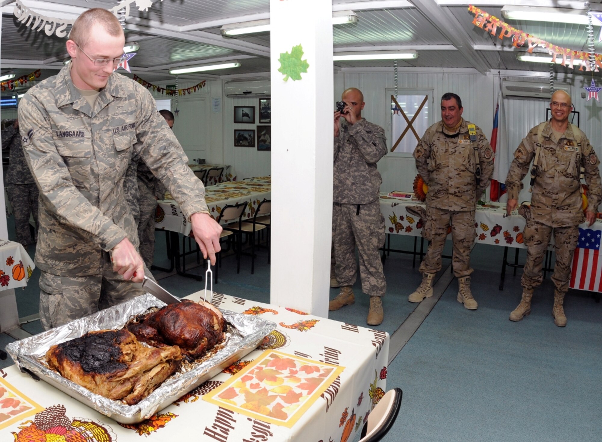 Airman 1st Class Neil Langgard, deployed to Camp Arena, Herat province, Afghanistan, cuts a turkey during a Thanksgiving celebration Nov. 25. Airman Langgard was selected to cut the turkey because he was the youngest servicemember in attendance. (U.S. Air Force photo/Tech. Sgt. Kevin Wallace)