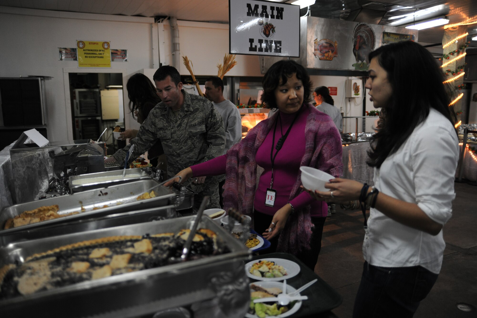 TRANSIT CENTER AT MANAS, Kyrgyzstan - University students prepare their lunch plates at the Ala' Too Dining Facility at the Transit Center at Manas Nov. 25.  Four local universities participated in a tour and ate a traditional holiday lunch with the troops in celebration of Thanksgiving Day.  (U.S. Air Force photo/Staff Sgt. Nathan Bevier)