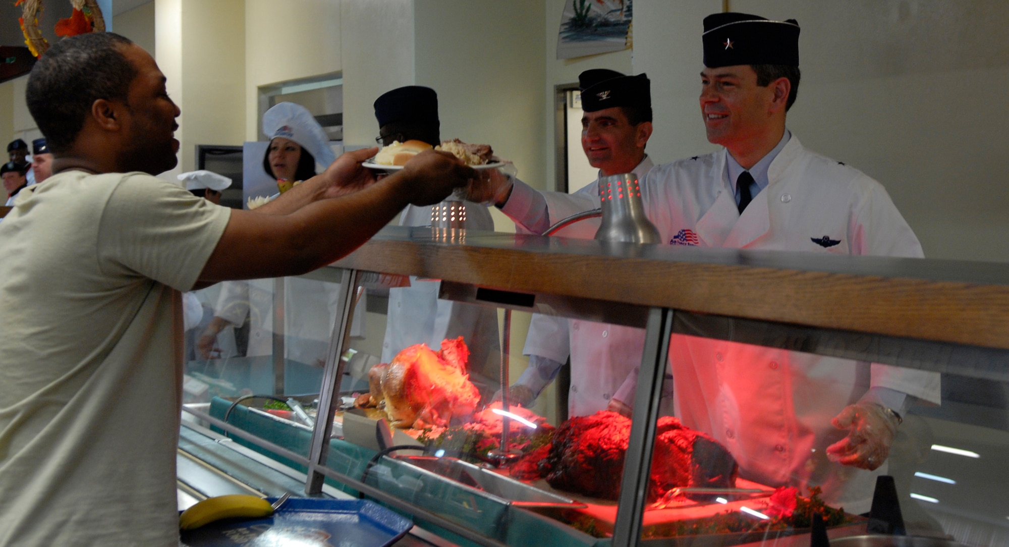 Brig. Gen. Kenneth S. Wilsbach, commander of the 18th Wing, volunteers his time to serve fresh sliced turkey to servicemembers Nov. 25 for the dining facility's Thanksgiving dinner. Servicemembers from all branches enjoy Thanksgiving dinner each year during the dining facility's festive dinner. (U.S. Air Force photo/ A1C Tara A. Williamson)