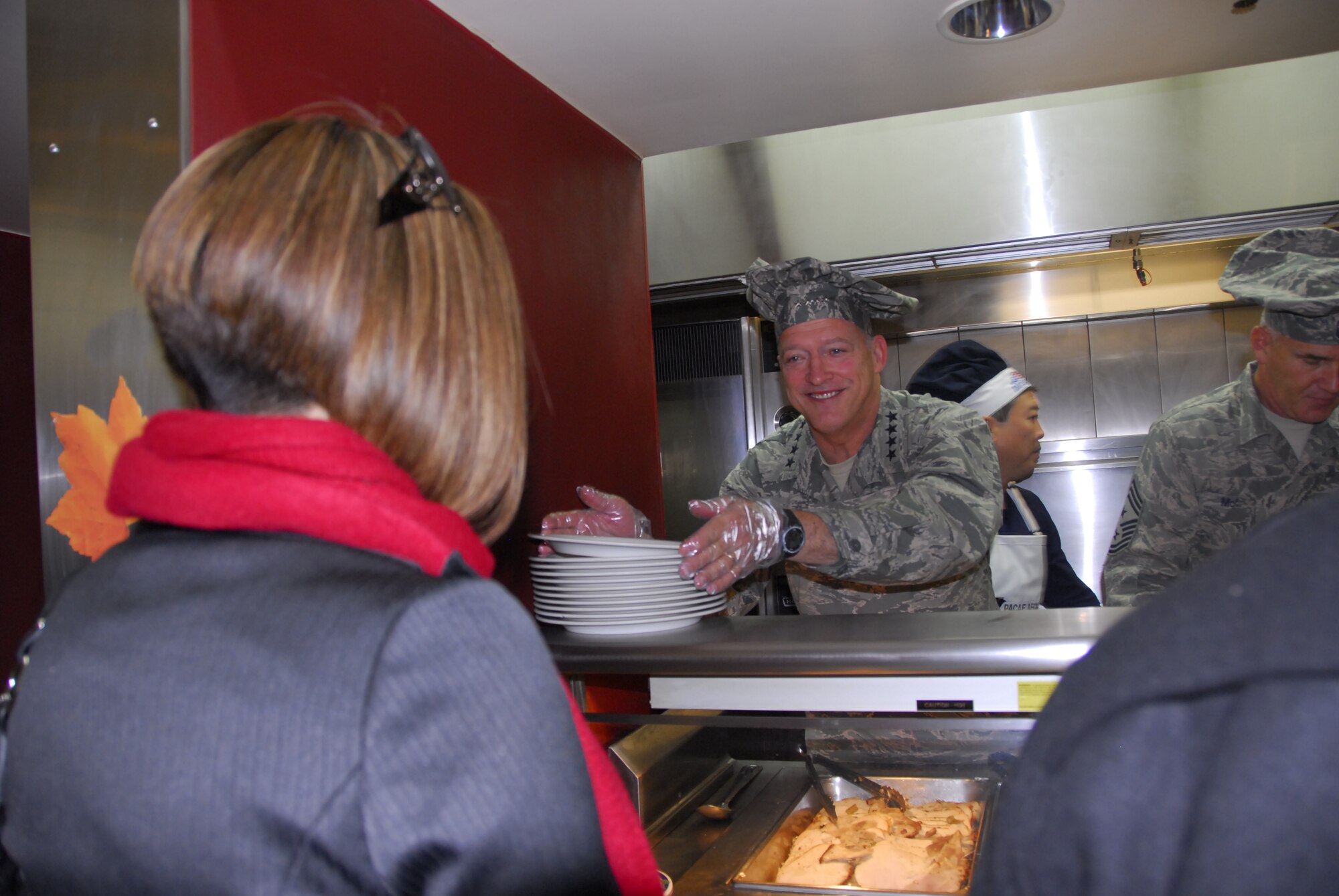 Gen. Gary North, Pacific Air Forces commander, grabs a plate to serve turkey during a Thanksgiving meal Nov. 25 at the Gingko Tree dining facility, Osan Air Base, Republic of Korea. (U.S. Air Force photo/Staff Sgt. Eunique Stevens)