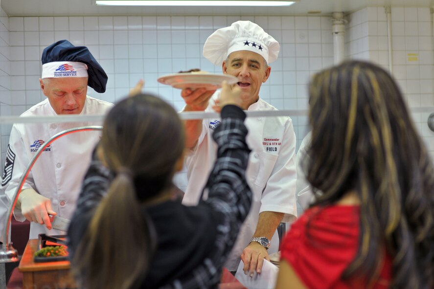 YOKOTA AIR BASE, Japan -- Yokota leaders serve a traditional thanksgiving meal Nov. 25 at Samurai Cafe dining facility. Lt. Gen. Burton Field, U.S. Forces Japan and Fifth Air Force commander, serves traditional roast turkey for the single service members and deployed families. (U.S. Air Force photo/Osakabe Yasuo)