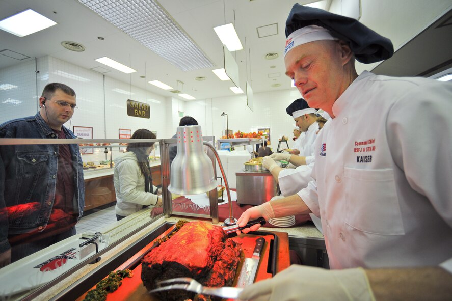 YOKOTA AIR BASE, Japan -- Yokota leaders serve a traditional thanksgiving meal Nov. 25 at Samurai Cafe dining facility. Command Chief Master Sgt. Richard Kaiser, U.S. Forces, Japan and Fifth Air Force, serves roast beef for the single service members and deployed families. (U.S. Air Force photo/Osakabe Yasuo) 