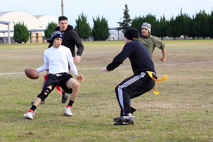 Paul Torres, Air Traffic Control crew 2 quarterback, attempts to rush the football past crew 1 defenders during the annual ATC Turkey Bowl at Penny Lake here Nov. 24. Crew 2 defeated crew 1 with a score of 52 - 22. Torres made sure to bring out the best in all of the players on his team by providing good throws and tactical rushes as opportunities arose.