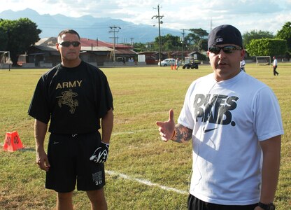 SOTO CANO AIR BASE, Honduras - Sgt. Kristopher Douglas (right), coach of the Soto Cano Army flag football team, discusses battle strategy with his team before the sixth annual "Turkey Bowl" here Nov. 24.  The base Air Force team would nudge past the Army Team 30-12. (Air Force photo, Capt. John T. Stamm)