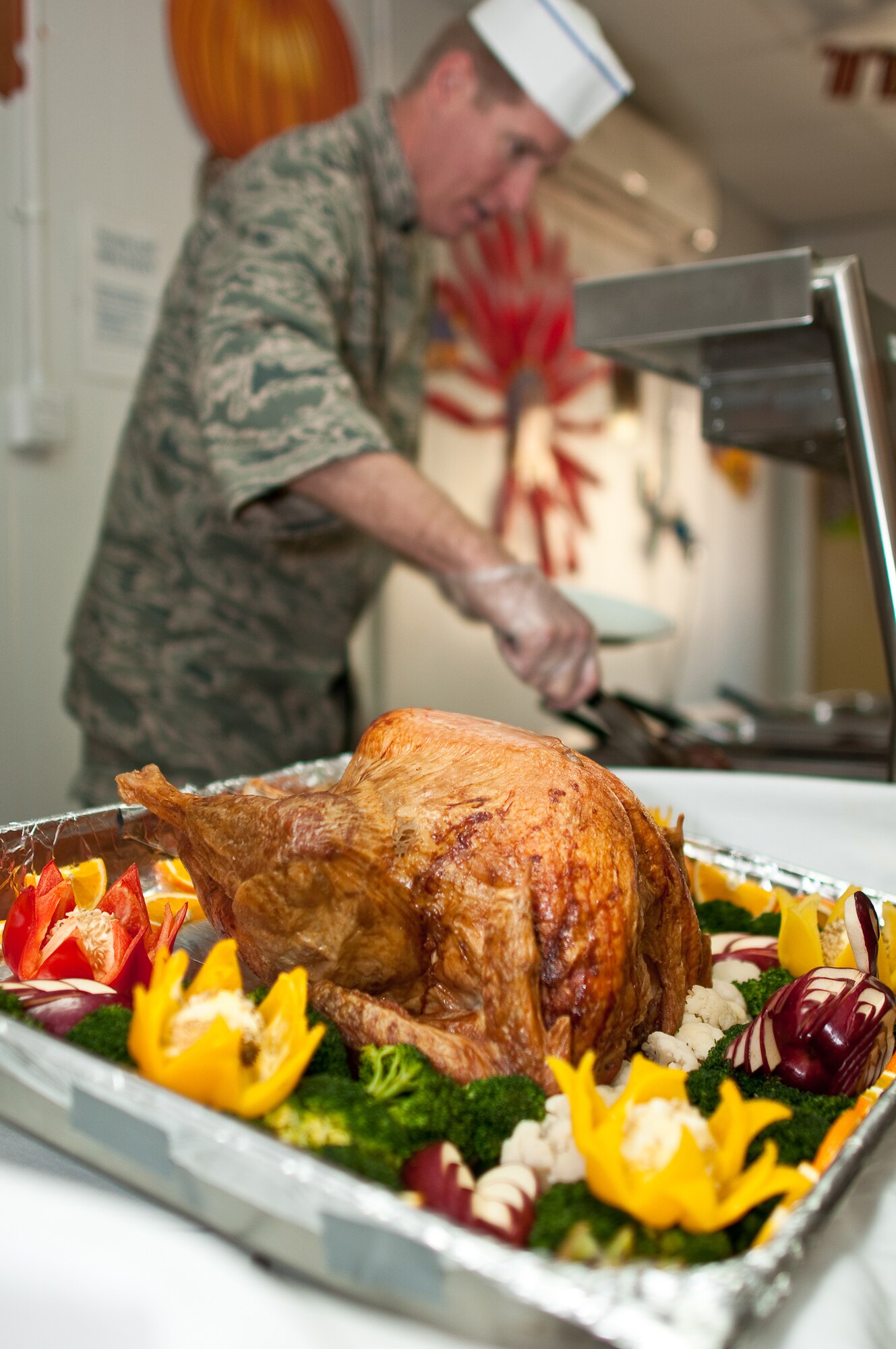 SOUTHWEST ASIA -- Col. Tal Metzgar, commander of the 387th Air Expeditionary Group, prepares to serve Thanksgiving Day meals to Airmen assigned to an undisclosed air base here Nov. 25, 2010. The 387th provides base operating support to the primary airlift gateway for the Iraqi theater of operations. (U.S. Air Force photo by Maj. Dale Greer/Released)