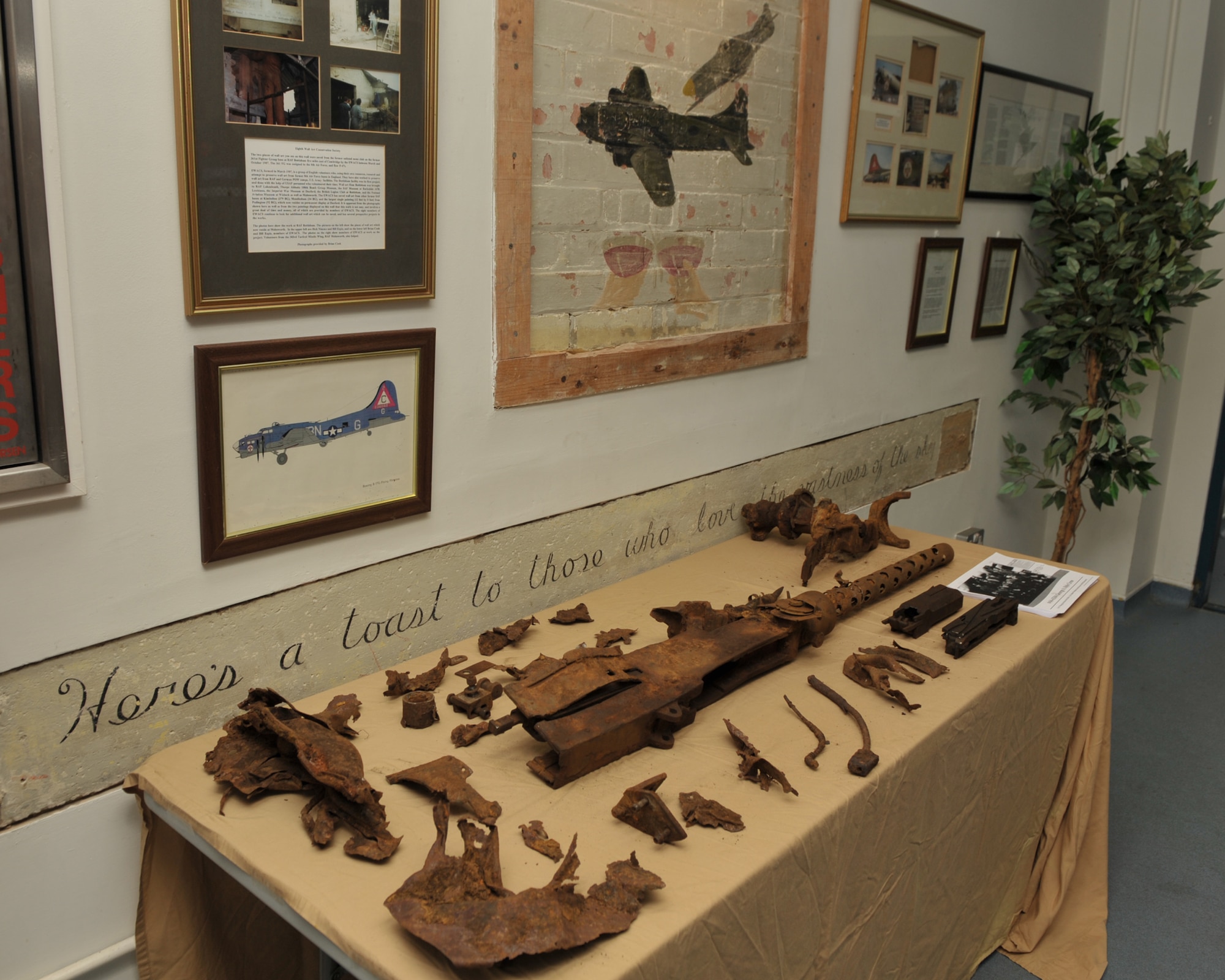One of the 13 machine guns aboard B-17G 44-6504 when it crashed on the English-Scottish border on December 16, 1944, is displayed on the JAC’s Thunderbird Lounge dedicated to another 303rd Bomb Group (Heavy) B-17.  The gun was recovered by hikers Kevin and Carole Ryder while walking in the Cheviot Hills in 2008.   U.S. Air Force photo by Staff Sgt. Javier Cruz.