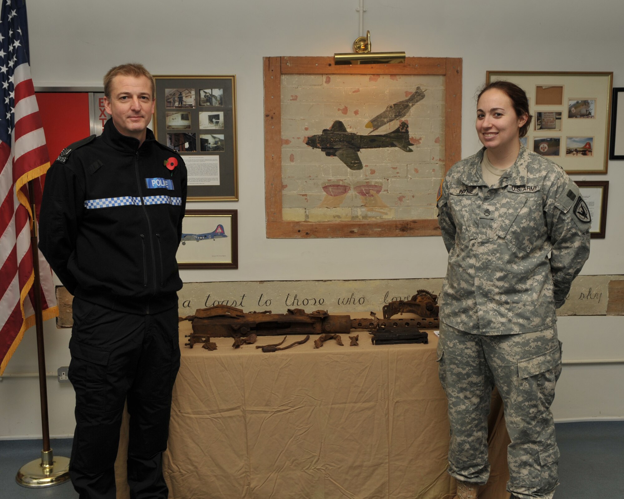 Northumbria Police Sergeant Kevin Smith, with U.S. Army Staff Sgt. Elizabeth H. Payne, Assistant JAC Historian at a ceremony November 9th where a machine gun from a B-17 Flying Fortress was returned to RAF Molesworth almost 66 years after it left on a combat mission on December 16, 1944 and crashed in the Cheviot Hills.  SSgt. Payne is the granddaughter of a B-17 WWII navigator  U.S. Air Force photo by Staff Sgt. Javier Cruz.