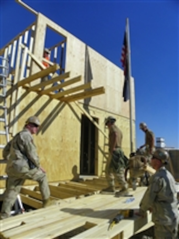 Capt. John DeBerard, commanding officer of Naval Mobile Construction Battalion 18, and Chief Petty Officer Joseph Zaleski confer about safety as Seabees assigned to Naval Mobile Construction Battalion 18 construct a Southwest Asian Hut at Kandahar Air Field, Afghanistan, on Nov. 12, 2010.  Naval Mobile Construction Battalion 18 is a reserve component battalion operating in the RC South Region of Afghanistan.  