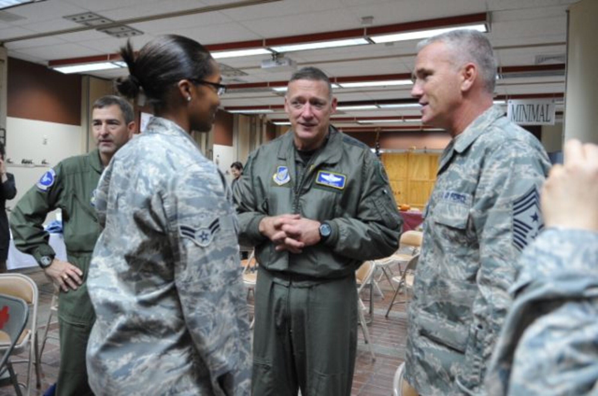 Gen. Gary North, Pacific Air Forces commander, center, and Chief Master Sergeant Sgt. Brooke McLean, PACAF command chief, right, talk with Airmen before a Thanksgiving meal Nov. 25 at the Gingko Tree dining facility, Osan Air Base, Republic of Korea. (U.S. Air Force photo/Staff Sgt. Eunique Stevens)
