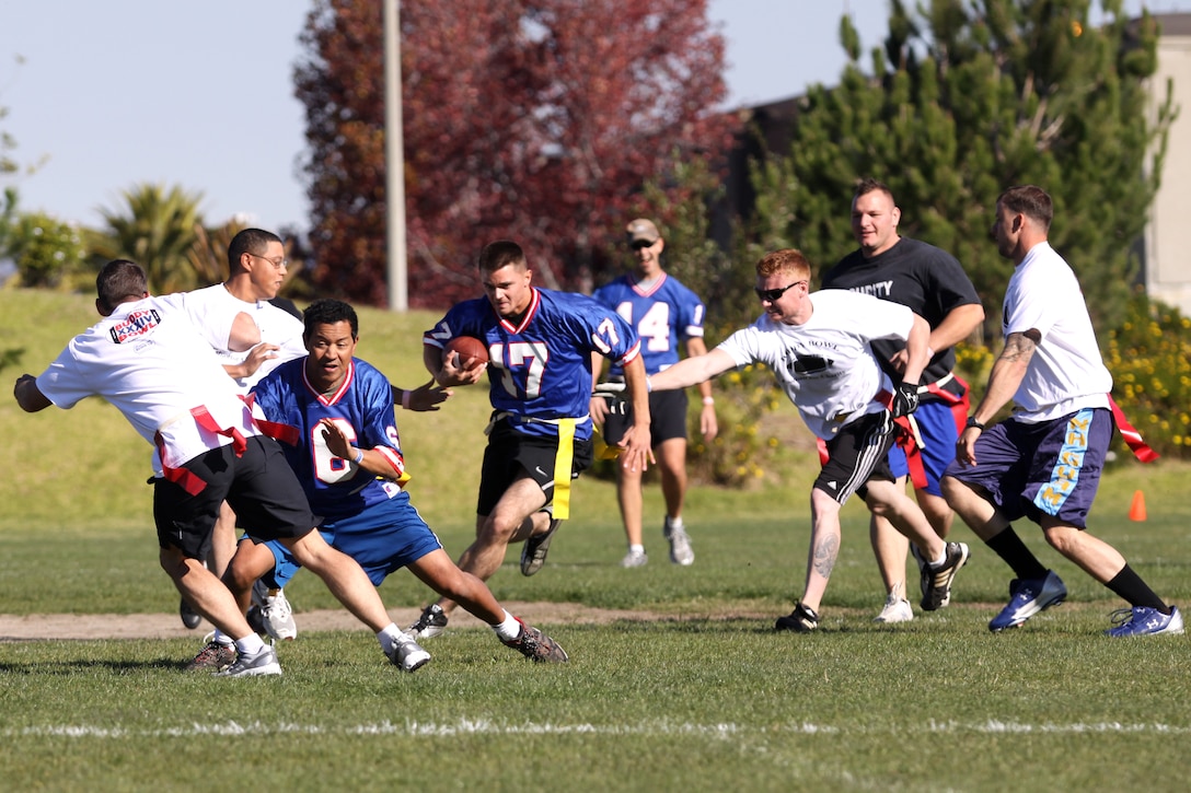 Paul Catino, number 17, makes his way through the defensive line during the annual Buddy Bowl flag-football tournament at Camp Pendleton’s 11 Area football field, Nov. 27. The Buddy Bowl raises money to benefit military personnel injured in battle and children of Marines who were killed in combat.