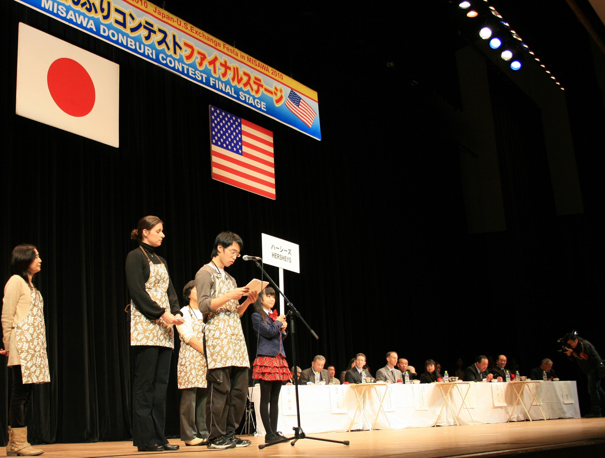 Misawa Air Base,  JAPAN -- Team Hersheys makes an appeal to the judges at the first Misawa Donburi Contest at the Misawa Civic Center Nov. 27, 2010. Teams consisting of U.S. and Japanese citizens competed to create a new recipe for donburi, a traditional rice-based Japanese dish. Out of five competing teams, Team Hersheys was voted the winner by a panel of judges consisting of community leaders including the mayor of Misawa City, the Commander of the 35 Fighter Wing and the Commander of the Misawa Naval Air Facility. Each year, the city holds several community events as part of Misawa's Japanese-U.S. cultural exchange program. (U.S. Photo by Captain Darrick B. Lee/released)