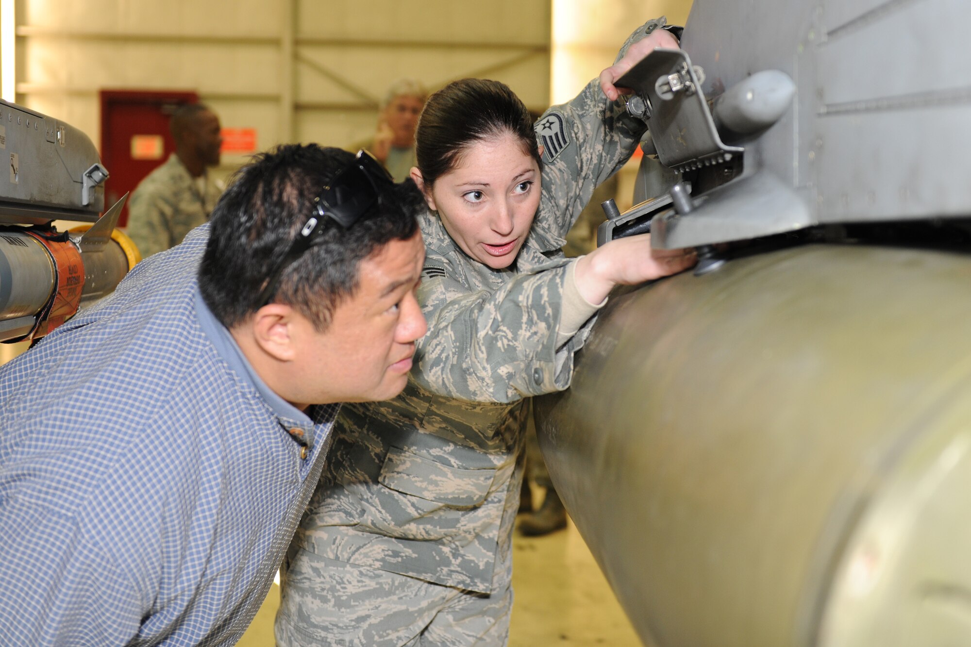 KUNSAN AIR BASE, Republic of Korea -- Staff Sgt. Shadon Gray, 8th Maintenance Operations Squadron, explains the importance of securing munitions into place on an aircraft to Brian Uy, Broker in charge for LT Services in Hawaii, during a visit to the base Nov. 22. Mr. Uy was part of a distinguished visitor group that accompanied Gen. Gary North, Pacific Air Forces commander, to various bases within the command during the week. (U.S. Air Force photo/Staff Sgt. Jonathan Pomeroy)
