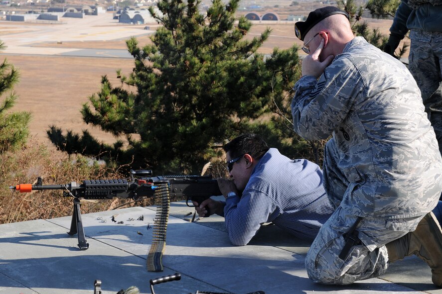 KUNSAN AIR BASE, Republic of Korea -- Kyle Nakamura, Division Manager of Tunista Pacific Rim, Honolulu, Hawaii, takes aim down range with a rifle as security forces members instruct him during a visit to the base Nov. 22.  Mr. Nakamura was part of a distinguished visitor group that accompanied Gen. Gary North, Pacific Air Forces commander, to various bases within the command during the week. (U.S. Air Force photo/Staff Sgt. Jonathan Pomeroy) 

