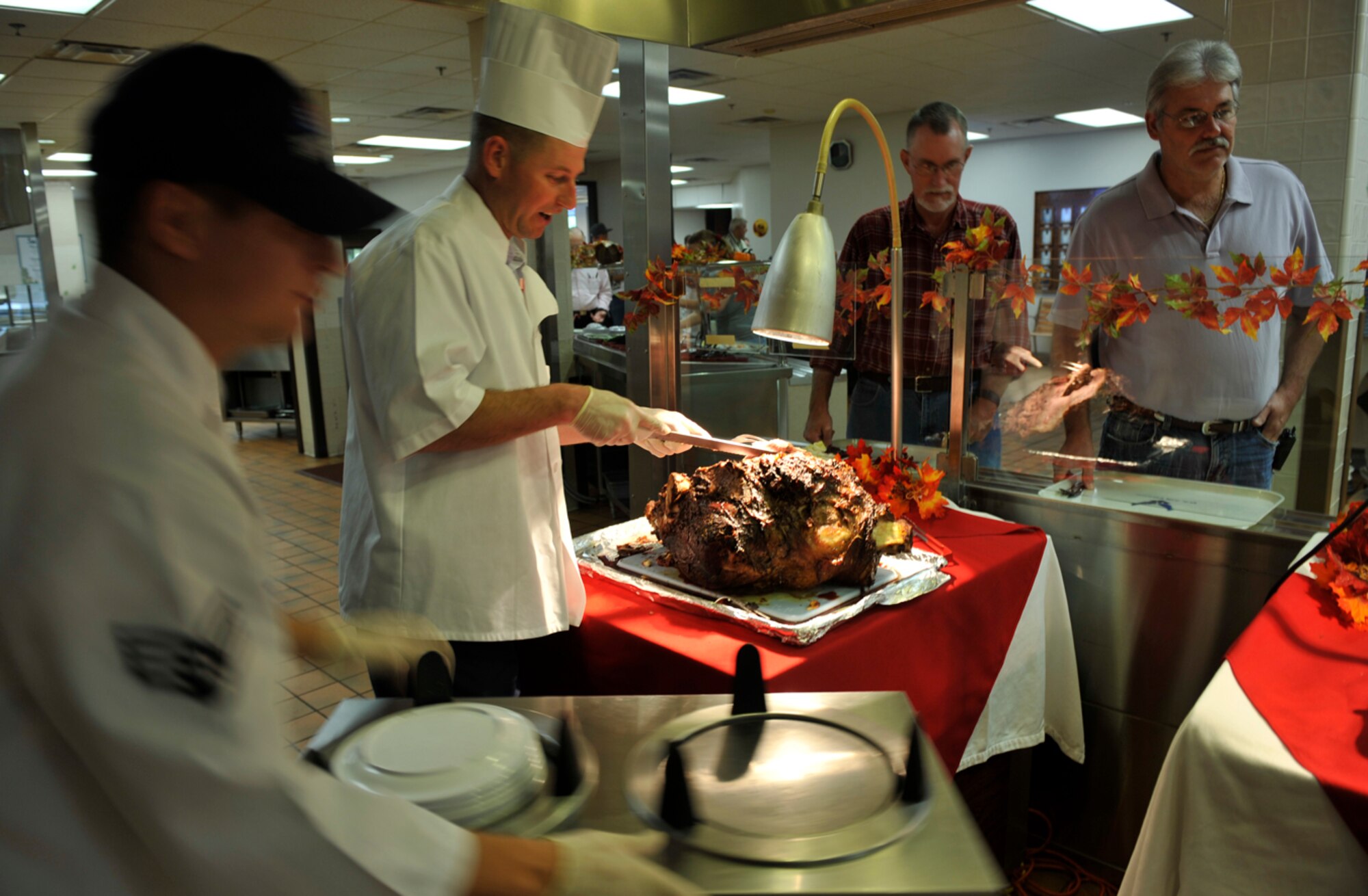 MOODY AIR FORCE BASE, Ga. -- Capt. Justin Secrest, 23rd Security Forces Squadron commander, serves roast beef to patrons of the Georgia Pines Dining Facility with the help of Senior Airman Brian Alicea, 23rd Force Support Squadron food services specialist, Nov. 25. Military members from base volunteered their time to help serve meals to Airmen, retirees and family members. (U.S. Air Force photo/Airman 1st Class Nicholas Benroth)(RELEASED)
