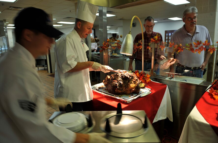 MOODY AIR FORCE BASE, Ga. -- Capt. Justin Secrest, 23rd Security Forces Squadron commander, serves roast beef to patrons of the Georgia Pines Dining Facility with the help of Senior Airman Brian Alicea, 23rd Force Support Squadron food services specialist, Nov. 25. Military members from base volunteered their time to help serve meals to Airmen, retirees and family members. (U.S. Air Force photo/Airman 1st Class Nicholas Benroth)(RELEASED)
