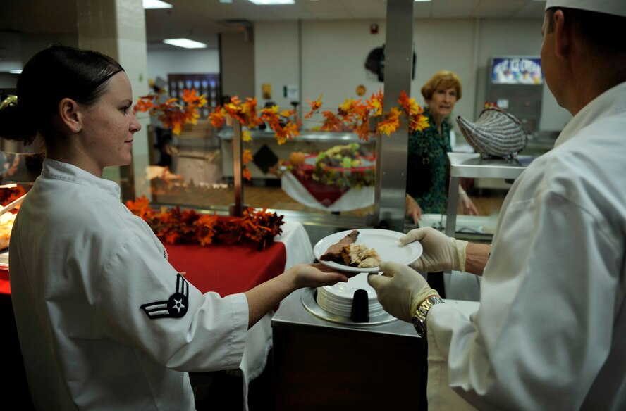 MOODY AIR FORCE BASE, Ga. -- Airman 1st Class Ashton Nixon, 23rd Force Support Squadron food services specialist, hands a plate of food to the next person in line during a Thanksgiving meal Nov. 25. Military members and volunteers alike joined to help serve a Thanksgiving meal to military members, retirees and family members. (U.S. Air Force photo/Airman 1st Class Nicholas Benroth)(RELEASED)

