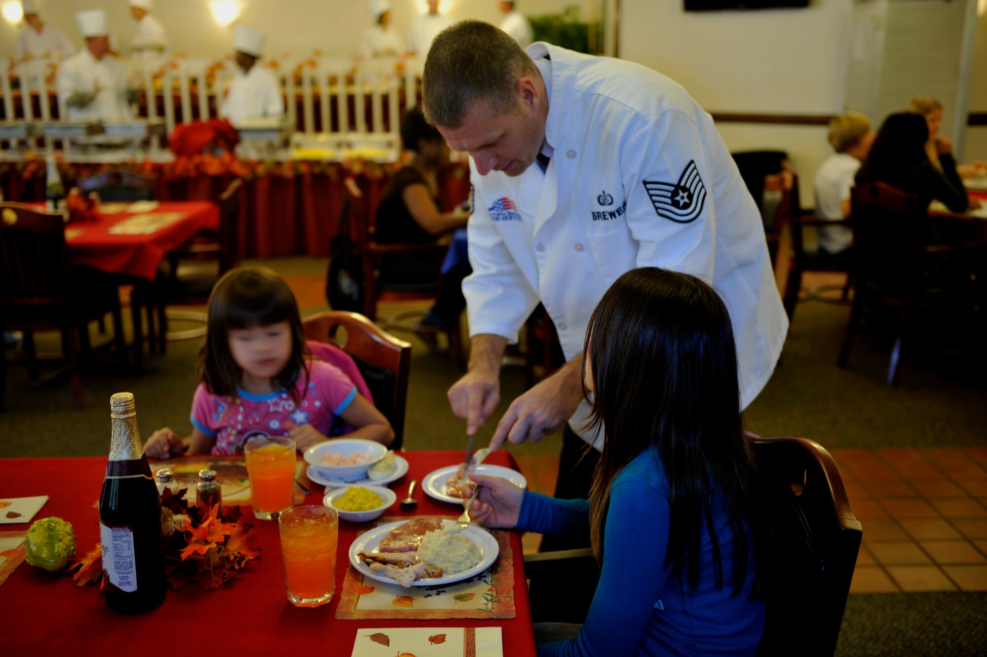 MOODY AIR FORCE BASE, Ga. -- Tech. Sgt. Patrick Brewer, 23rd Force Support Squadron food services specialist, and his family enjoy a Thanksgiving meal during his shift at the Georgia Pines Dining Facility Nov. 25. Military members from base volunteered their time to help serve meals to Airmen, retirees and family members. (U.S. Air Force photo/Airman 1st Class Nicholas Benroth)(RELEASED)
