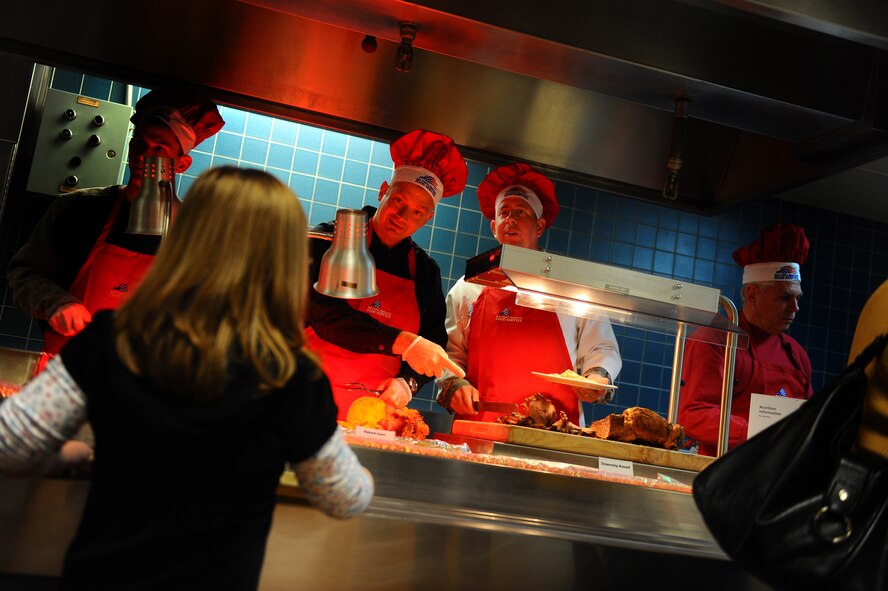 OFFUTT AIR FORCE BASE, Neb. - Col. Daniel Courtois, 55th Maintenance Group commander, and Brig. Gen. John N.T. Shanahan, 55th Wing commander, carve up Thanksgiving fare for members of Team Offutt at the Ronald L. King Dining facility for an annual Thanksgiving dinner Nov. 25.  Airmen, retirees and their families got a chance to have their Thanksgiving dinner professionally prepared by the Air Combat Command John L. Hennessy award winning Airmen while members of wing leadership served the food. U.S. Air Force photo by Josh Plueger (Released)
