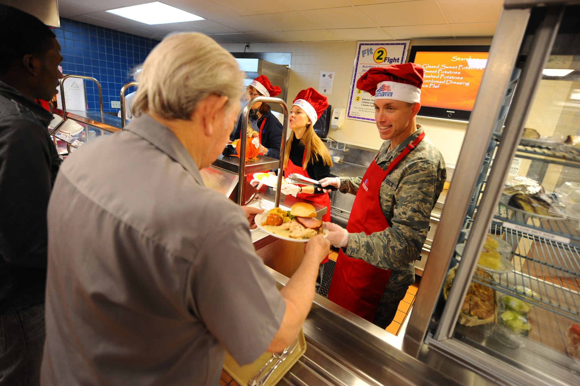 OFFUTT AIR FORCE BASE, Neb.- Col. Patrick Dawson, 55th Medical Group commander, hands out plates full of food at the Ronald L. King Dining facility for an annual Thanksgiving dinner Nov. 25.  Airmen, retirees and their families got a chance to have their Thanksgiving dinner professionally prepared by the Air Combat Command John L. Hennessy award winning Airmen while members of wing leadership served the food. U.S. Air Force photo by Josh Plueger (Released)
