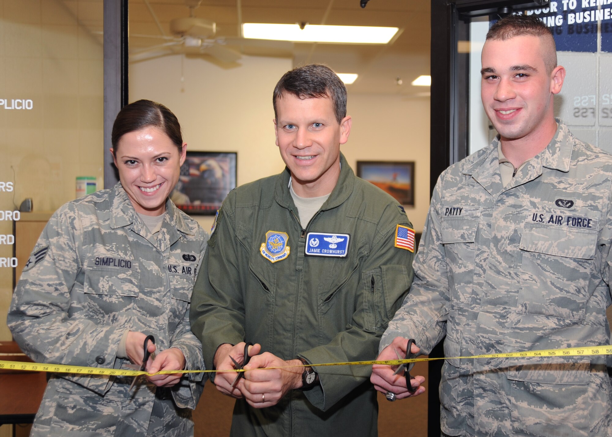 Senior Airman Gianna Simplicio, 22nd Force Support Squadron fitness assessment cell NCOIC, Col. Jamie Crowhurst, 22nd Air Refueling Wing commander, and Airman 1st Class Craig Patty, 22nd Civil Engineer Squadron structural journeyman, cut a measuring tape to mark the opening of the new Fitness Assessment Cell, Nov. 19, 2010, McConnell Air Force Base, Kan. The new office presents a centralized location for test administrators to perform Air Force physical fitness assessments. (U.S. Air Force photo/Airman 1st Class Katrina M. Brisbin)