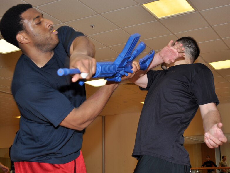 RAF MILDENHALL, England -- Tech. Sgt. Thomas Moore, Detachment 2, 25th Intelligence Squadron, and Tech. Sgt. Mitchell Lombard, 352nd Special Operations Group Manpower office, practice long-gun takeaways during a one-week Krav Maga class Oct. 26, 2010. The class is open to members assigned to the 352nd SOG and is taught by certified instructors from the unit's security forces flight. (U.S. Air Force photo/Tech. Sgt. Marelise Wood)
