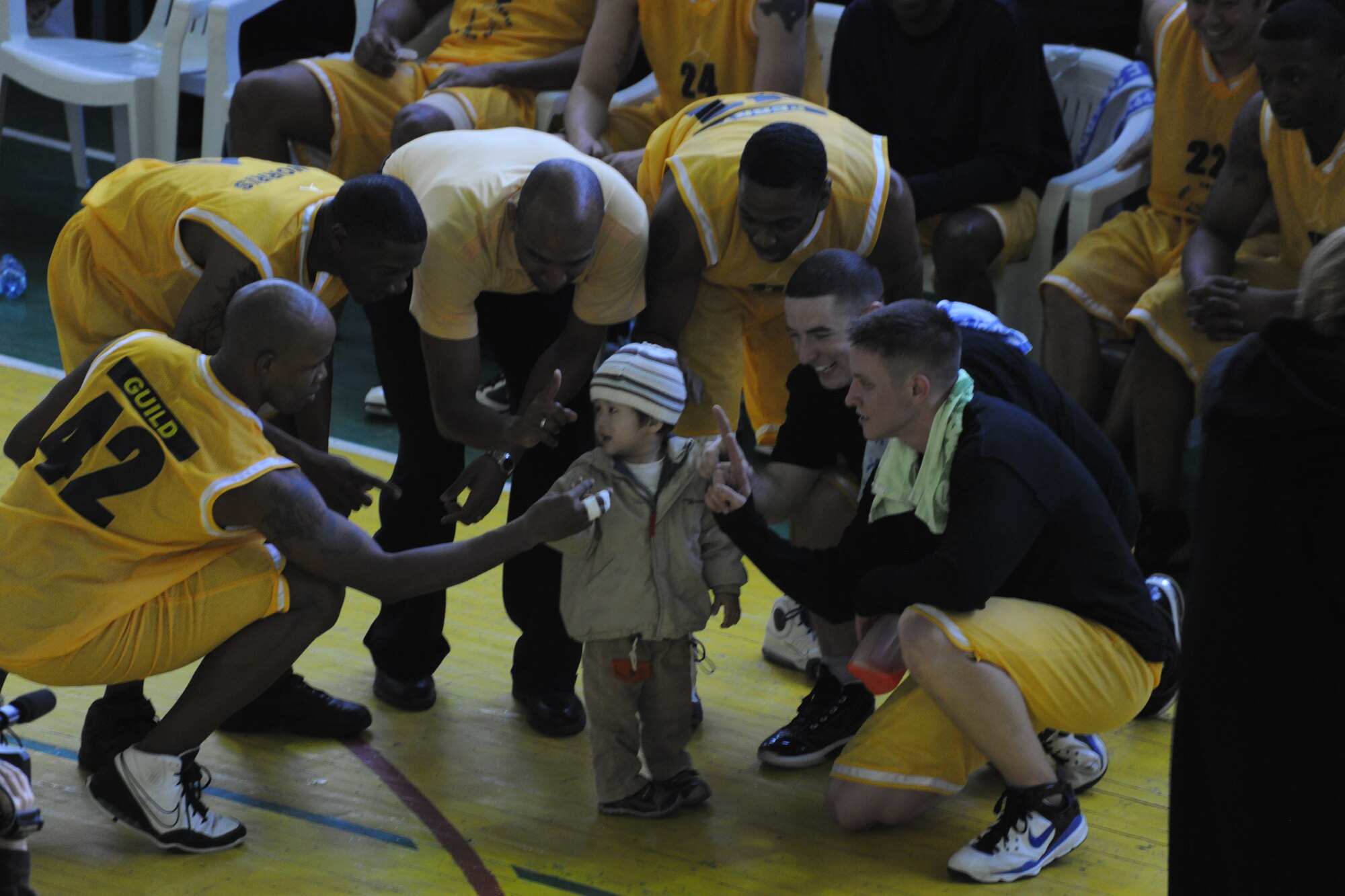 BISHKEK, Kyrgyzstan - Airmen from the Transit Center at Manas play with a child at the end of the second quarter of a basketball game against the Kyrgyz National University at the Kyrgyz Sports Palace in Bishkek, Nov. 27.  The Kyrgyz National Men's Team defeated the Transit Center team with a final score of 60-42.  (U.S. Air Force photo/Staff Sgt. Nathan Bevier)
