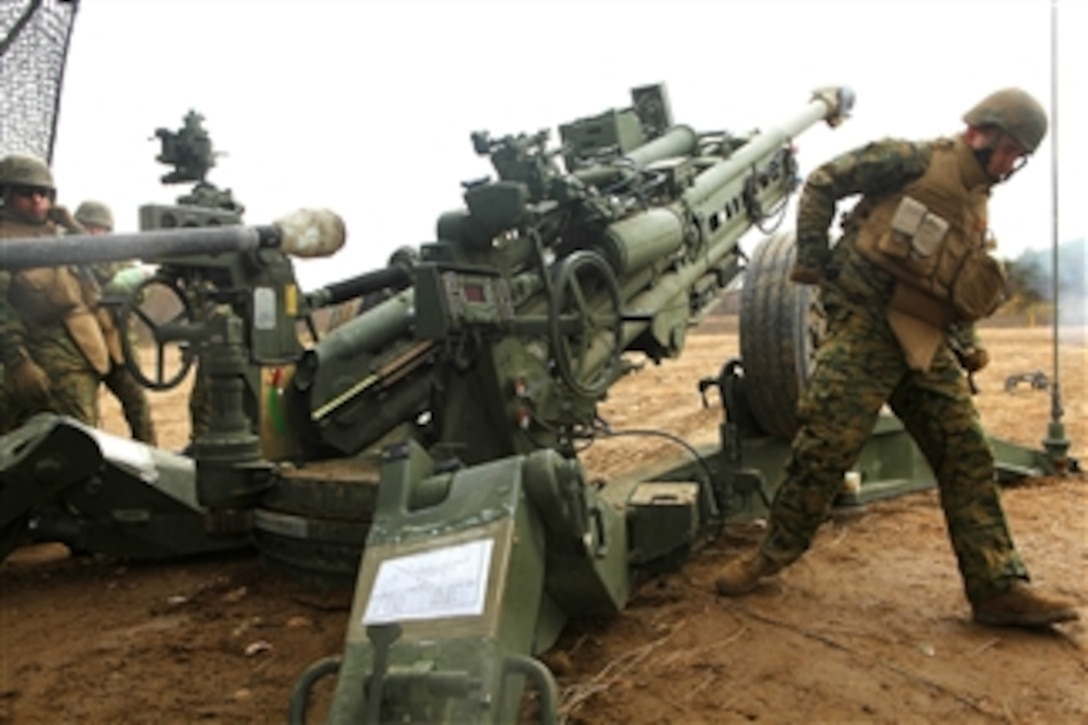 Gun Team Five fires a round from a M777A2 howitzer at Camp Sendai, Japan, in the Ojojihara Maneuver Area during Artillery Relocation Training Exercise 10-3 Ojojihara on Nov. 23, 2010.  The Marines are assigned to the 3rd Marine Division's, Battery B, 3rd Battalion, 12th Marine Regiment, III Marine Expeditionary Force.  The Marines are conducting live-fire artillery training to maintain operational readiness of the artillery battalion in support of the U.S. – Japanese security alliance.  