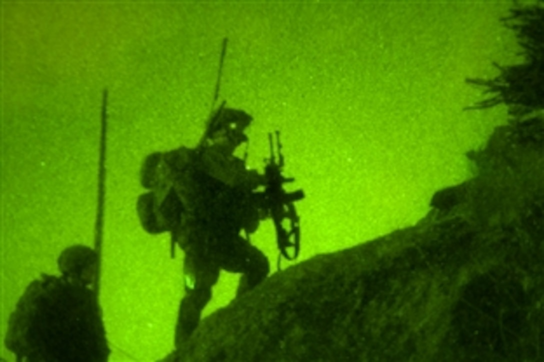 As seen through a night-vision device, U.S. and Afghan National Army soldiers scale treacherous terrain in the dead of night using the cover of night to move into suspicious villages on a mountainside in the Pech River Valley in eastern Afghanistan's Kunar Province, Nov. 23, 2010. The U.S. soldiers are assigned to Company B, 1st Battalion, 327th Infantry Regiment, Task Force Bulldog.
