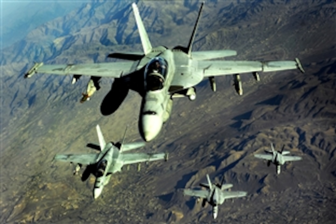 Four U.S. Navy F/A-18 Hornet aircraft fly over mountains during a mission in Afghanistan, Nov. 25, 2010.