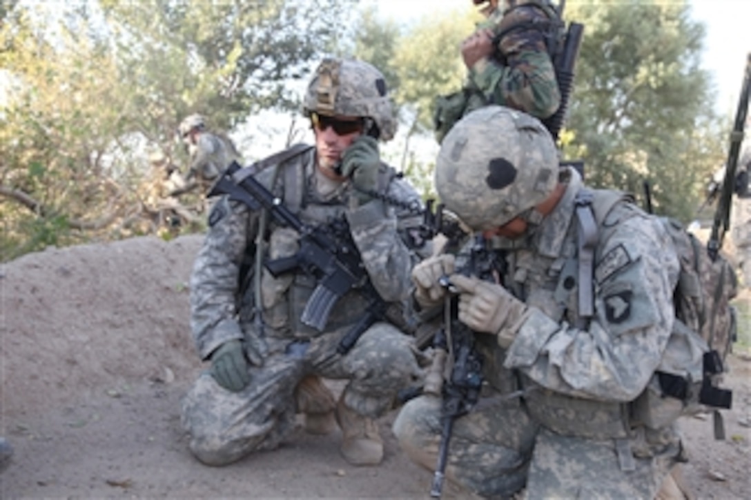U.S. Army 1st Lt. Andrew Moehl, of 2nd Platoon, Alpha Company, 1st Battalion, 502nd Parachute Infantry Regiment, 2nd Brigade Combat Team, 101st Airborne Division, radios in his team's status with the help of his Radio Transmitter Operator Spc. Joshua Rachal in Kandalay, Afghanistan, on Sept. 25, 2010.  U.S. soldiers worked hard to cut down trees in preparation for a new Command Observation Post being built in the area.  