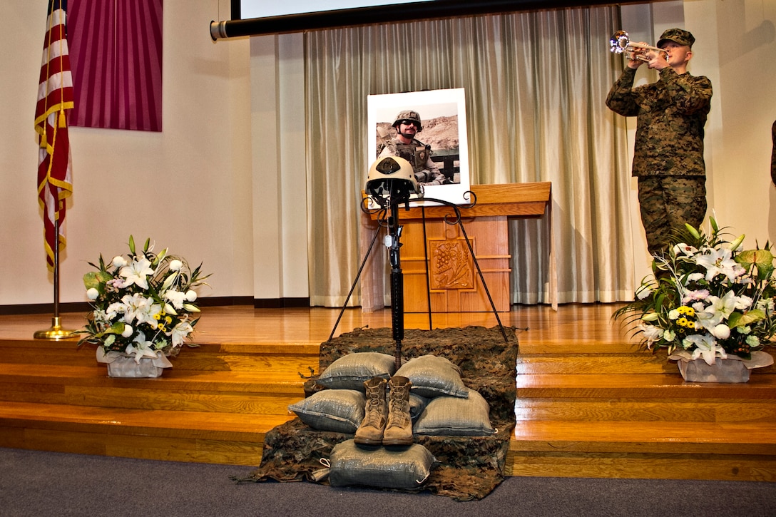 Cpl. Christopher Hanson plays taps during the memorial service of Sgt. Jason T. Smith at the Marine Memorial Chapel here Tuesday. Smith, who was attached to 7th Engineer Support Battalion, 1st Explosive Ordnance Disposal Company, 4th platoon, was killed in action Nov. 19 while conducting operations in Helmand Province, Afghanistan.