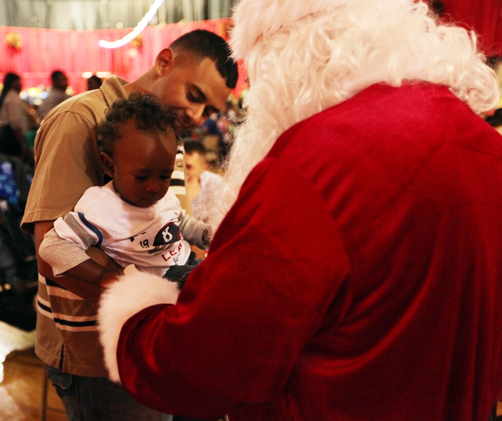 Santa Claus greets a child during a Combat Logistics Regiment 2, 2nd Marine Logistics Group, family Christmas party at the Goettge Memorial Field House aboard Camp Lejeune, Nov. 30, 2010. During the party approximately 300 personnel with the regiment, along with their family and friends, got their face painted, played video games, enjoyed food and refreshments, and won prizes. (U.S. Marine Corps photo by Pfc. Franklin E. Mercado)