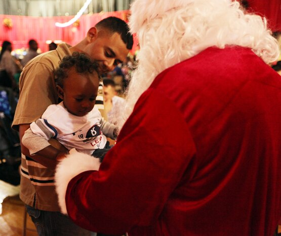 Santa Claus greets a child during a Combat Logistics Regiment 2, 2nd Marine Logistics Group, family Christmas party at the Goettge Memorial Field House aboard Camp Lejeune, Nov. 30, 2010. During the party approximately 300 personnel with the regiment, along with their family and friends, got their face painted, played video games, enjoyed food and refreshments, and won prizes. (U.S. Marine Corps photo by Pfc. Franklin E. Mercado)